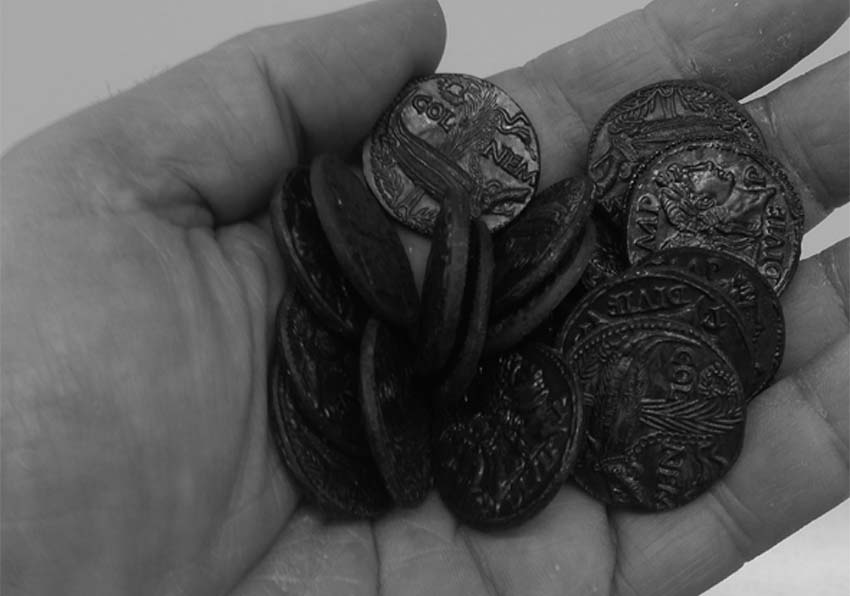 Una mà amb monedes antigues